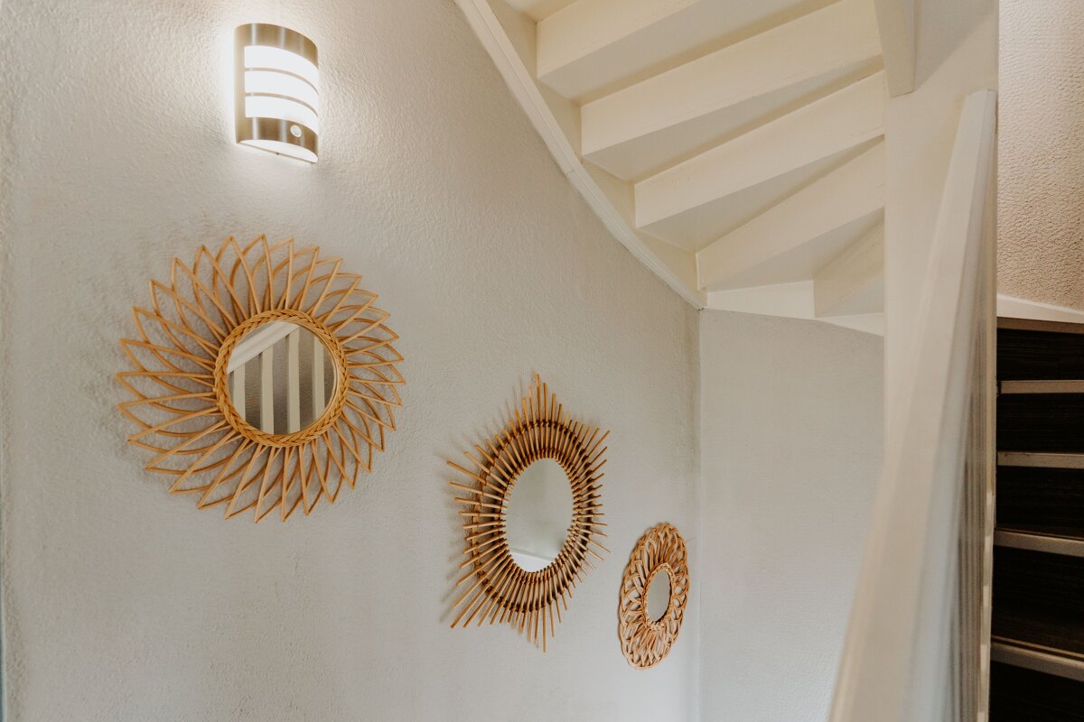 A spiral staircase with three mirrors on the wall