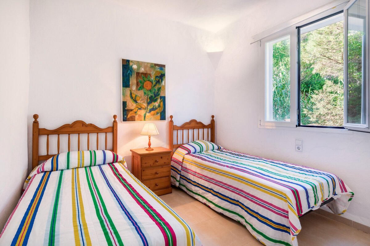 A bedroom with two beds and a painting on the wall