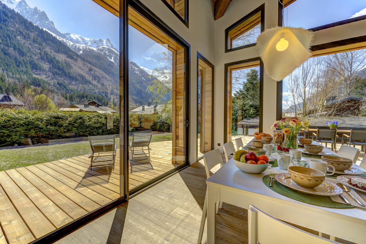 A dining room table with a bowl of fruit on it