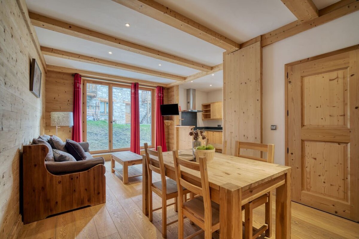 A living room with a wooden table and chairs