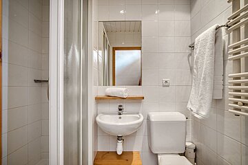 A bathroom with a sink toilet and mirror