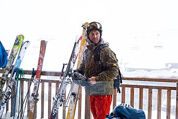 A man wearing a salomon backpack is standing in the snow