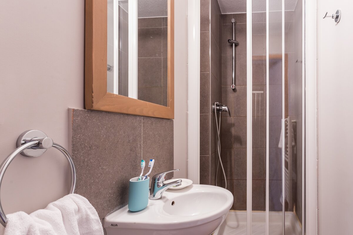 A bathroom with a sink a mirror and a shower