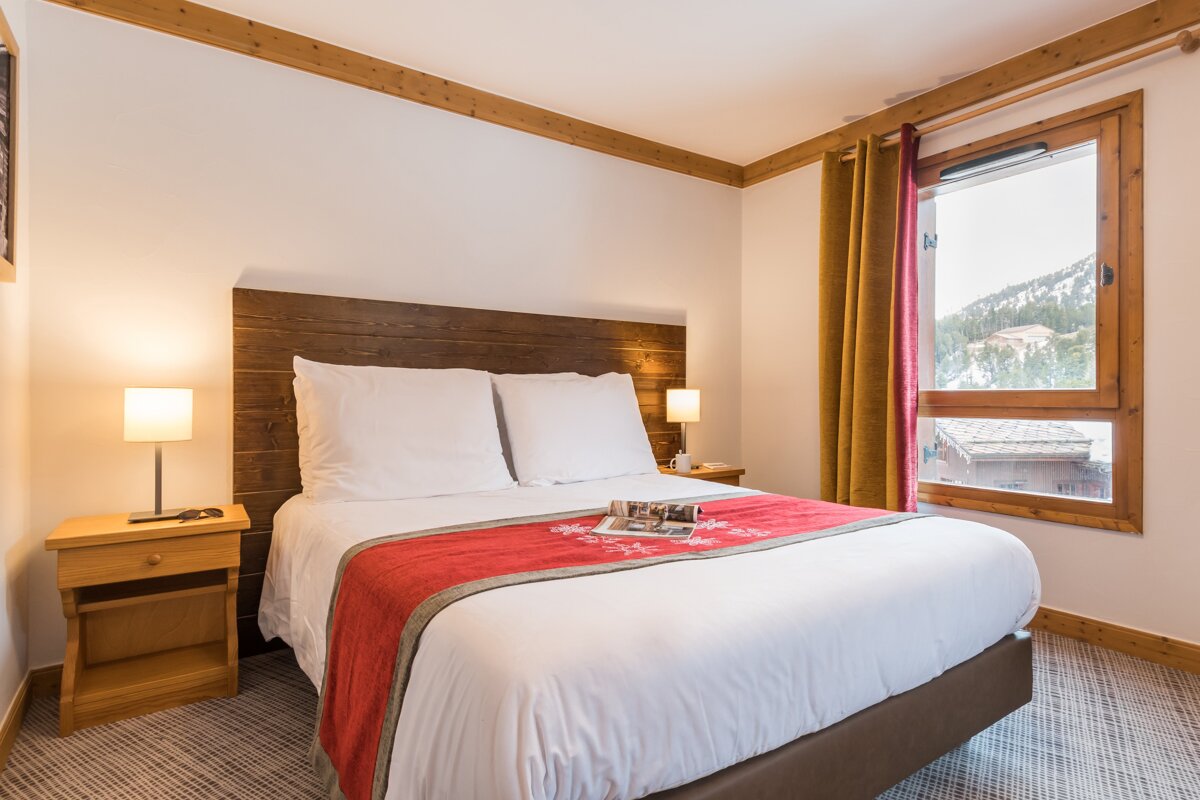 A bedroom with a large bed and a window