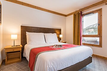 A bedroom with a large bed and a window