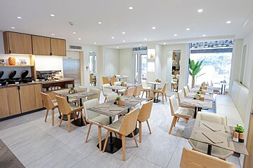 A restaurant with tables and chairs and a sign that says exit