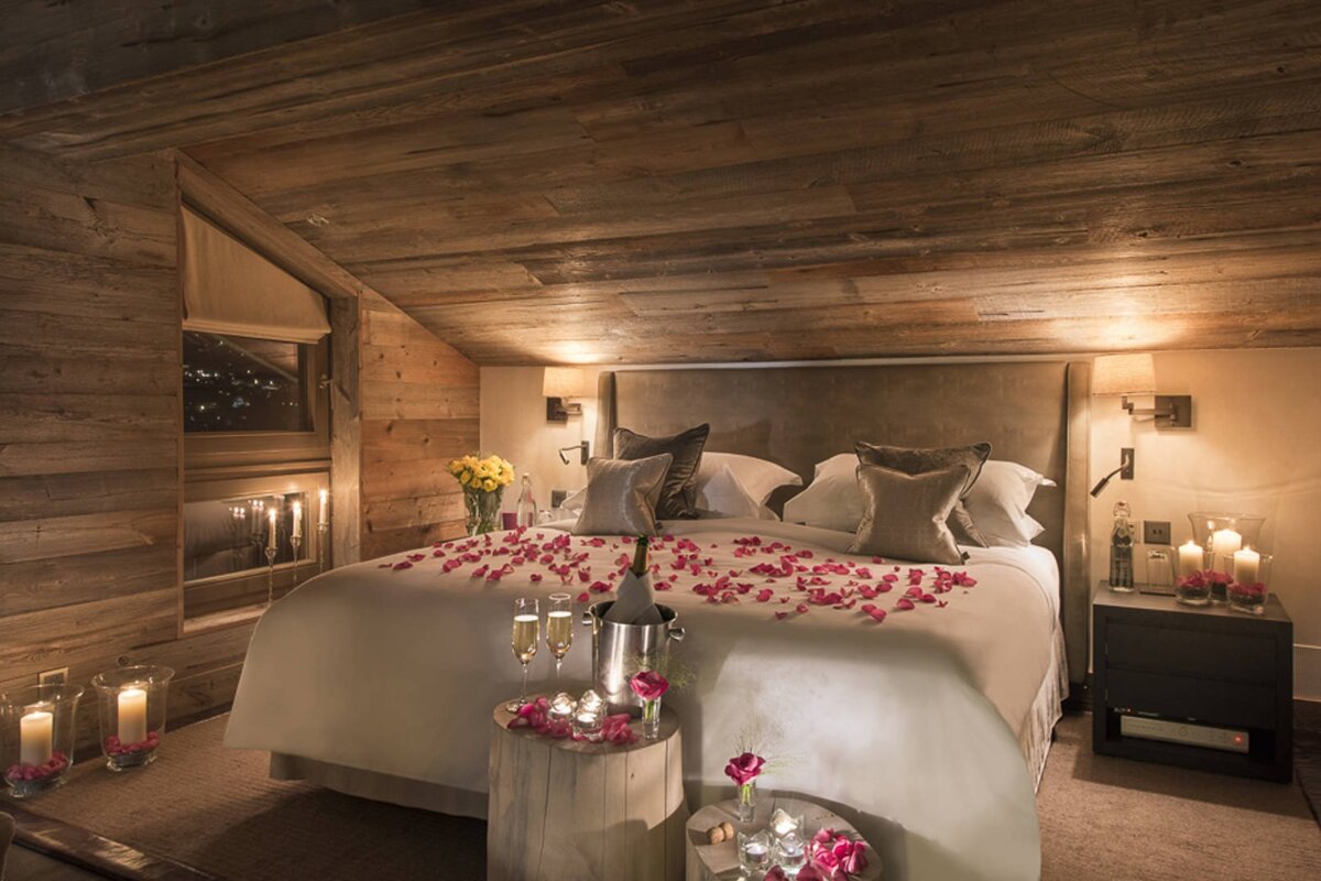 A bedroom with a bed covered in petals and candles