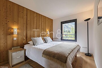 A bedroom with a bed and a window with the number 8 on the wall