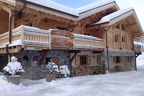 A snowy building with a sign that says hotel le cocoon