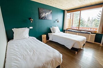 A bedroom with two beds and a painting on the wall