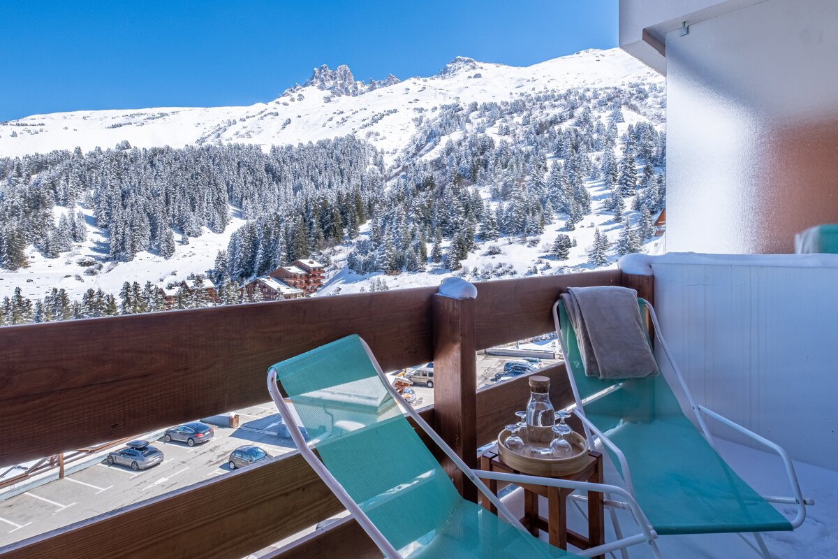 Two chairs on a balcony overlooking a snowy mountain