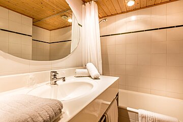 A bathroom with a sink a mirror and a bathtub