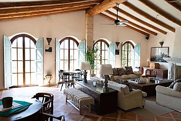 A living room with arched windows and a ceiling fan