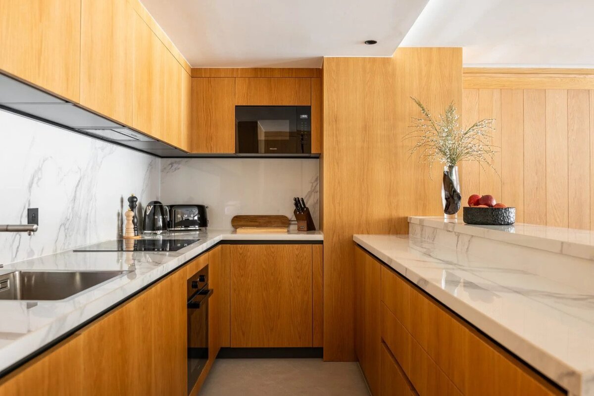 A kitchen with wooden cabinets and white counter tops