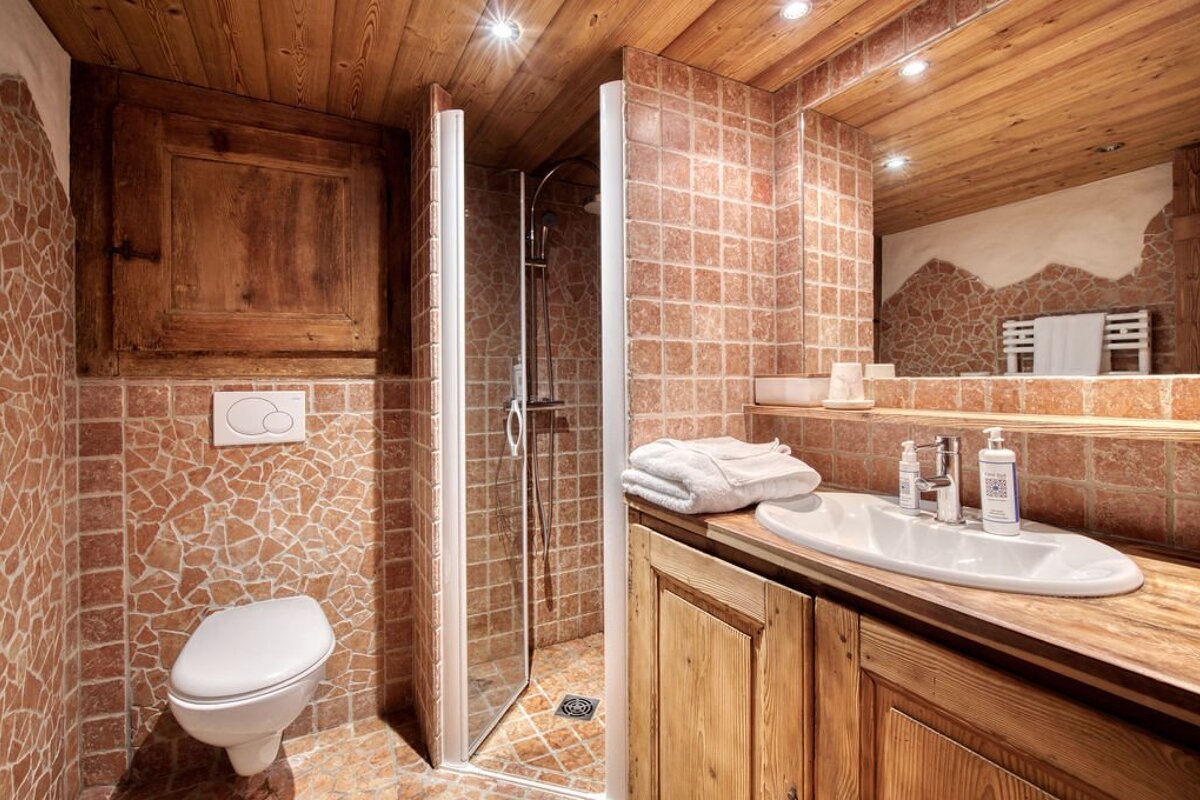 A bathroom with a toilet a sink and a mirror