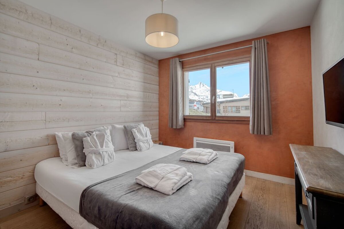 A bedroom with a large bed and a large window