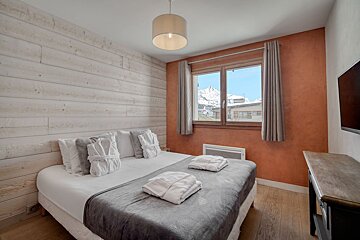 A bedroom with a large bed and a large window