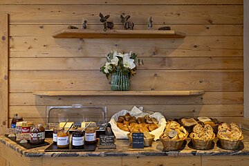 A wooden shelf with a vase of flowers on it