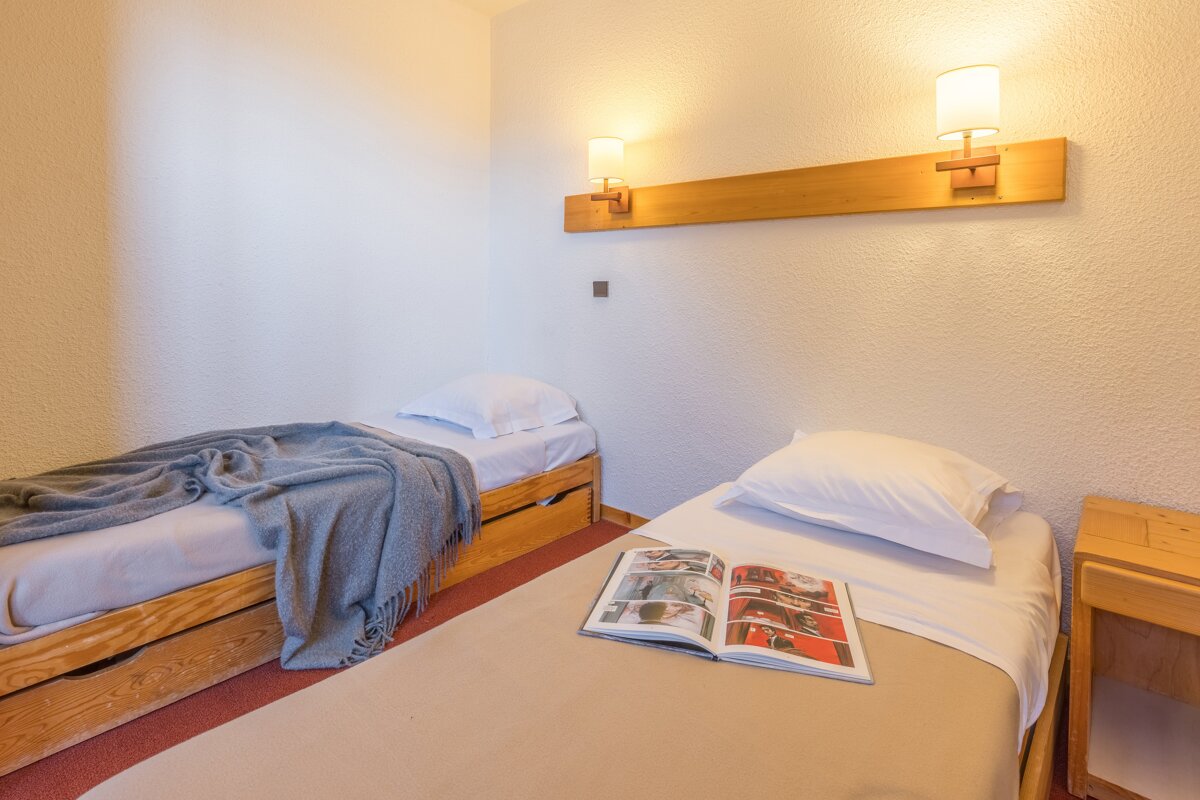 A bedroom with two beds and a book on the bed