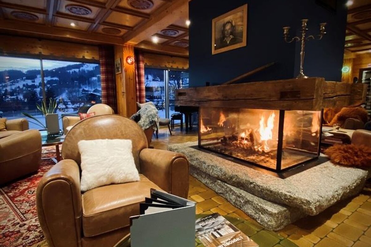 A leather chair sits in front of a fireplace with a magazine on the floor that says 