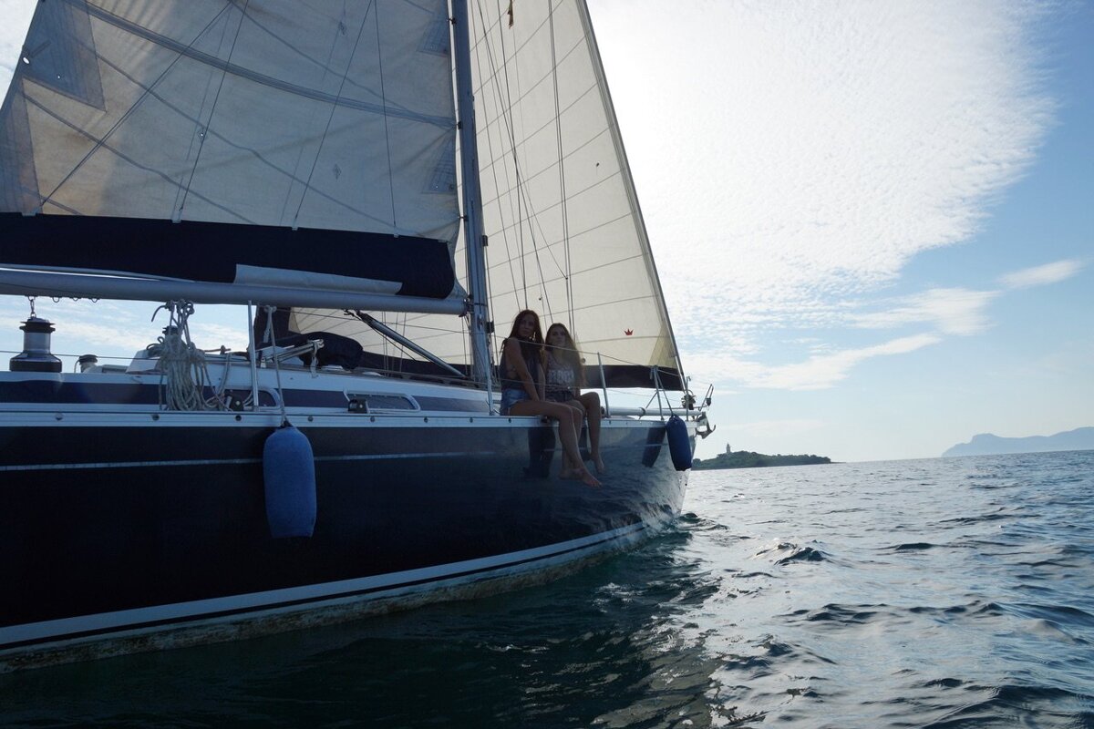 Two women sit on a sailboat in the ocean