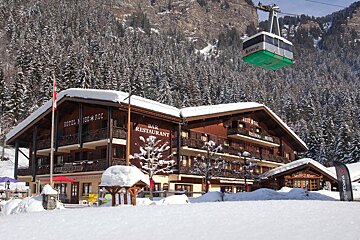 a hotel with a cable car passing over the roof