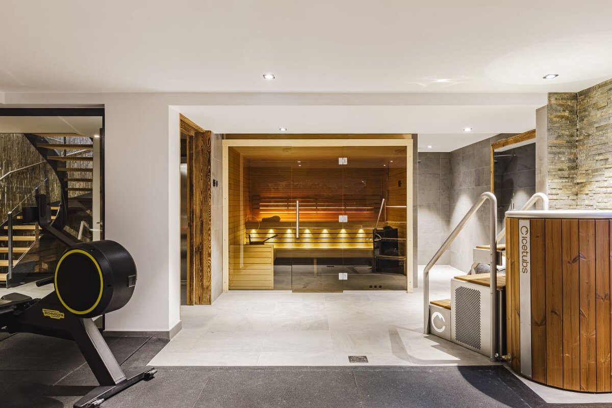 A gym with a staircase leading to a sauna