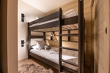 A bunk bed with a teddy bear on it