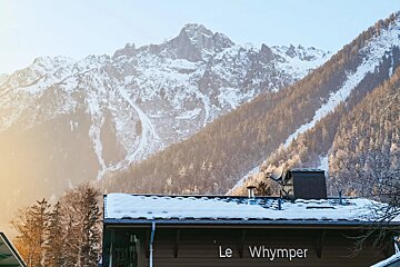 A snowy mountain behind a building that says le whymper