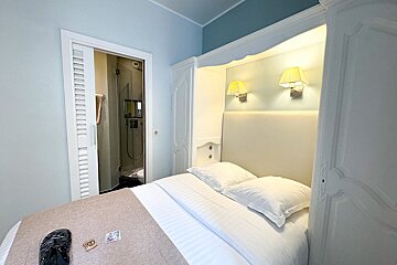 A hotel room with a bed and a few cards on it