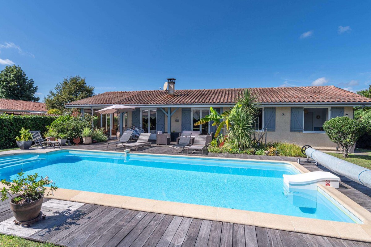 A house with a large swimming pool in front of it
