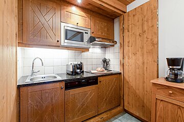 A kitchen with wooden cabinets and a coffee maker