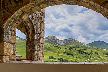 A view of a mountain range through a stone archway