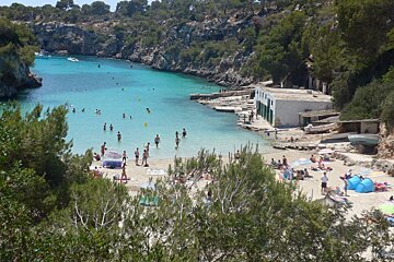 people swimming in the sea in a small cove