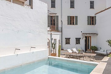 A white building with a swimming pool in front of it