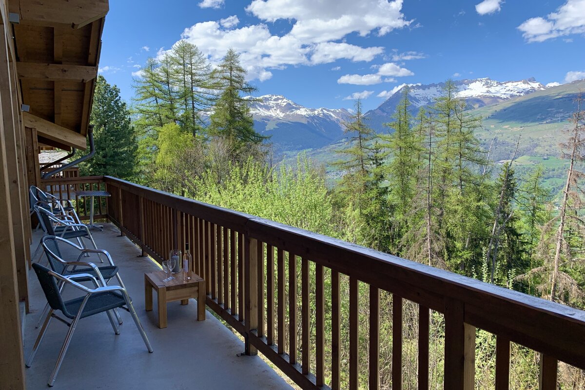 A balcony with a view of mountains and trees