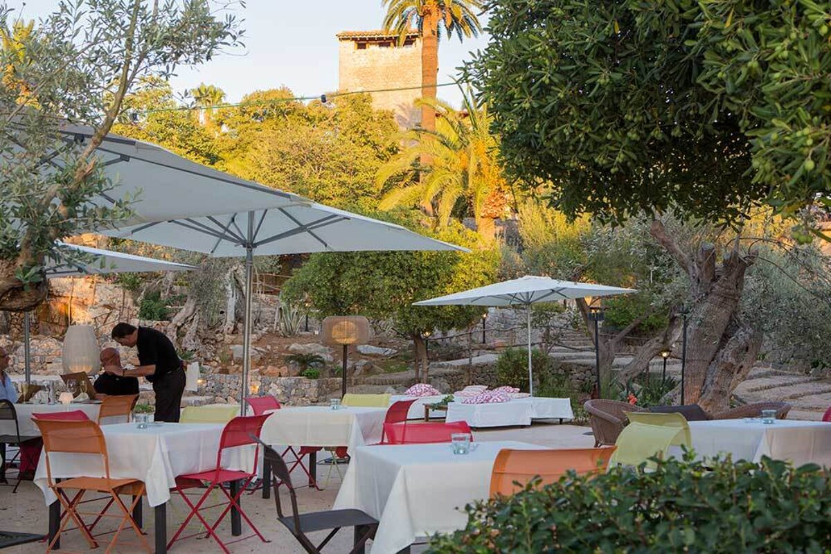 A man stands behind a table with an umbrella over it