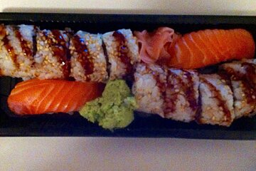 a long black plate filled with sushi