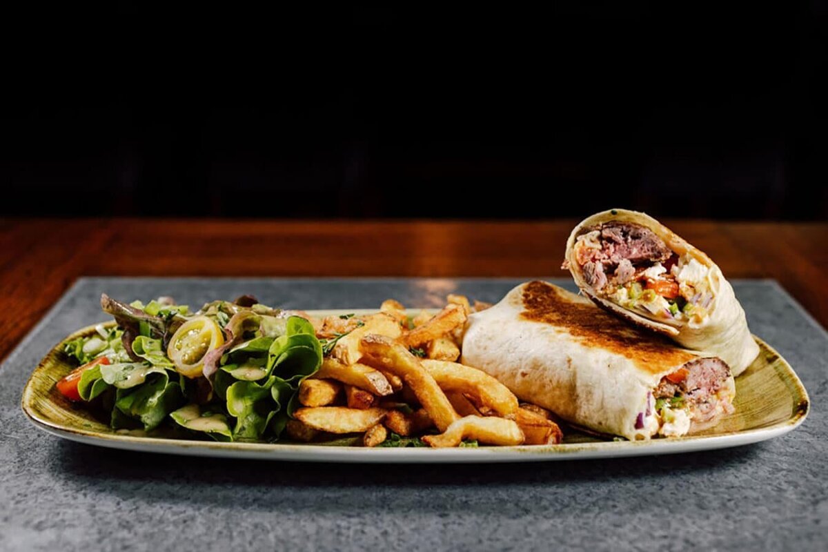 A plate of food with a wrap and french fries