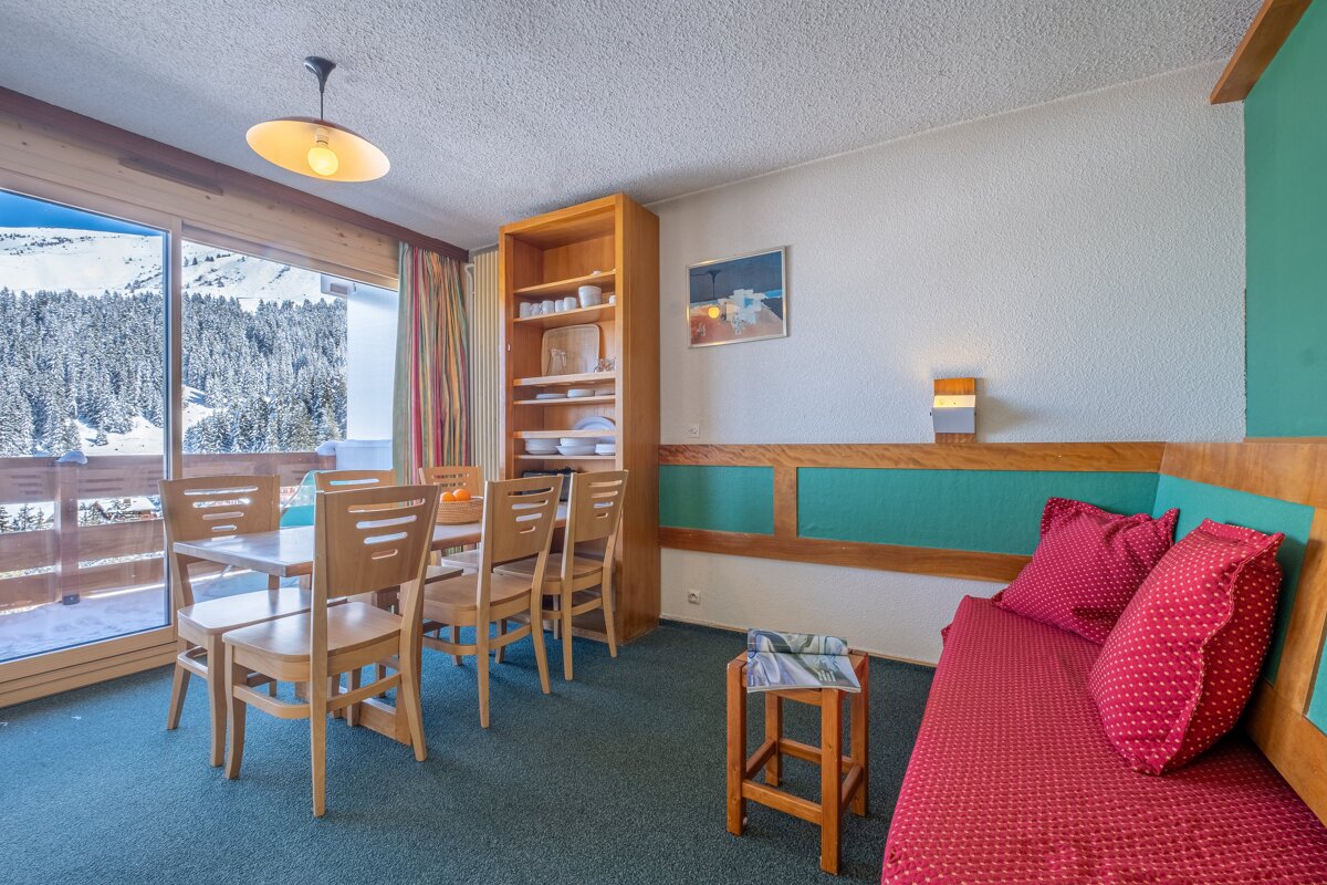 A living room with a table and chairs and a picture on the wall