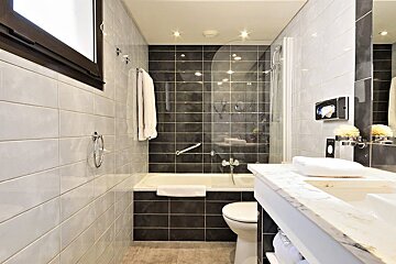 A bathroom with black and white tiles and a sink