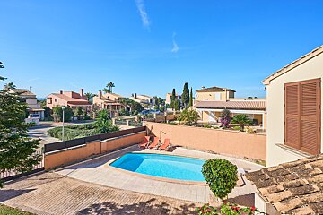 A large swimming pool is in the backyard of a house
