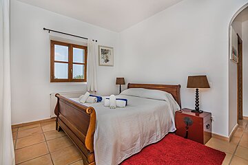 A bedroom with a sleigh bed and two lamps