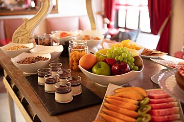A buffet table with a bowl of fruit on it