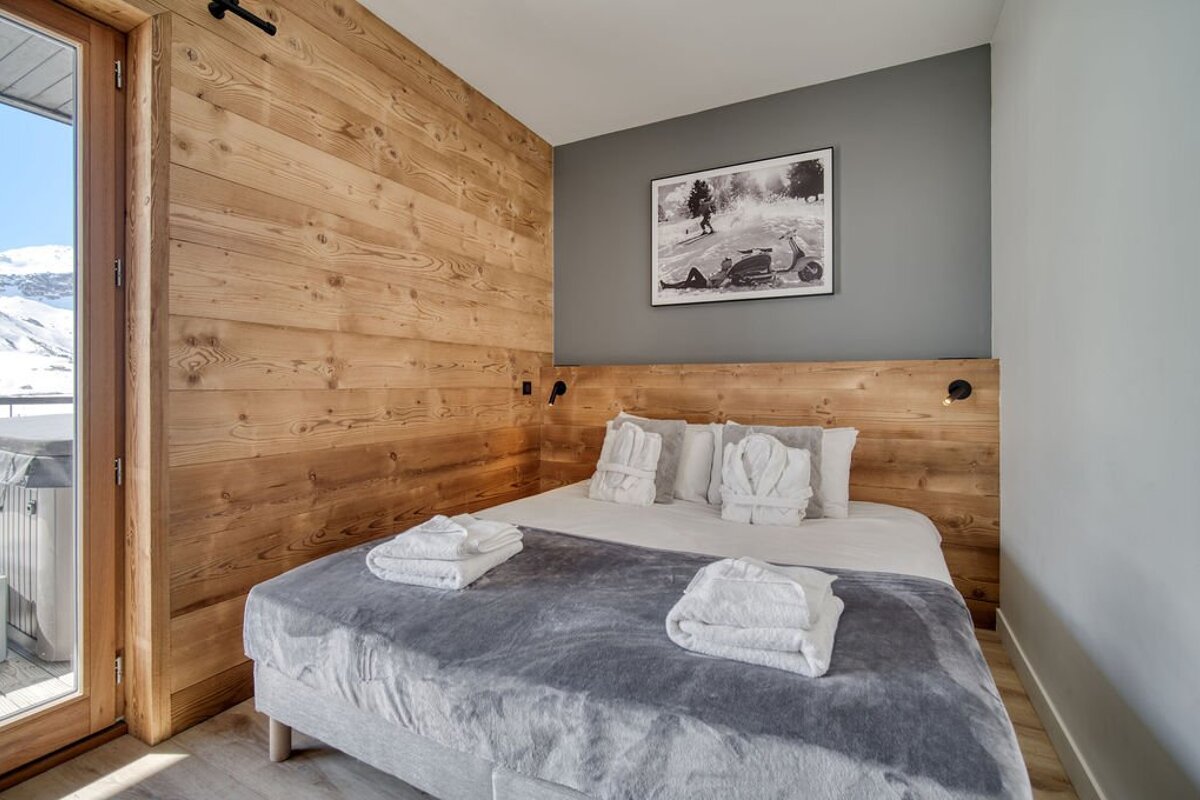 A bedroom with a picture on the wall above the bed