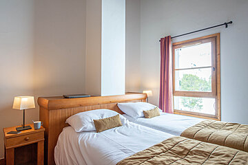 A bedroom with two beds and a window