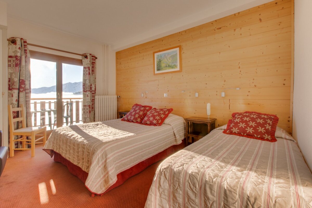 A bedroom with two beds and a picture on the wall