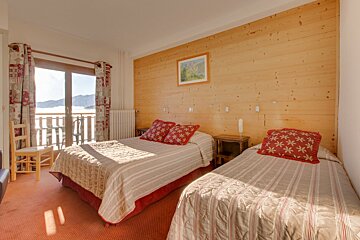 A bedroom with two beds and a picture on the wall