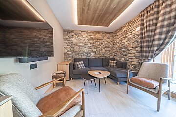 A living room with a stone wall and a flat screen tv