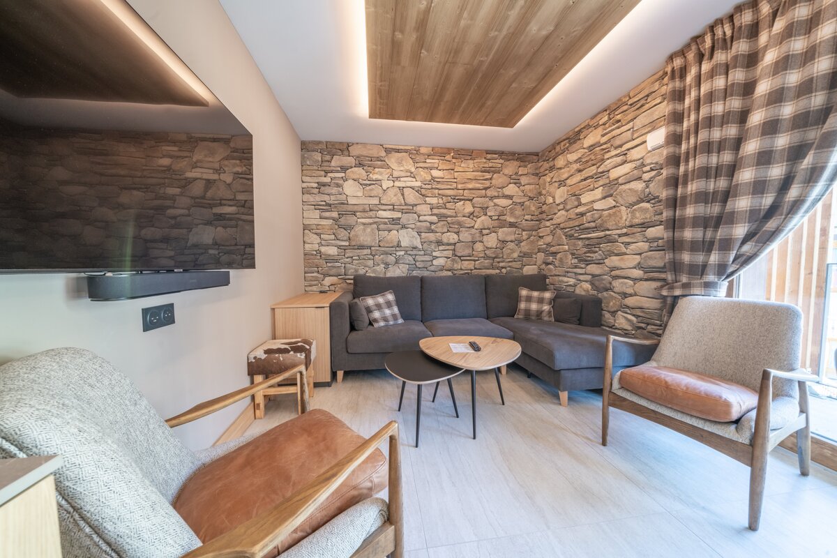 A living room with a stone wall and a flat screen tv